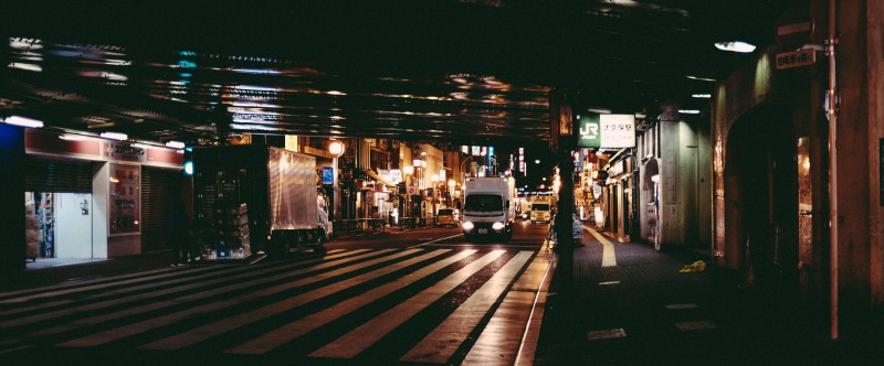 A delivery truck driving on a street at night