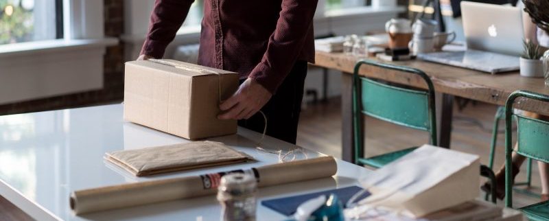 A person backing items into a box